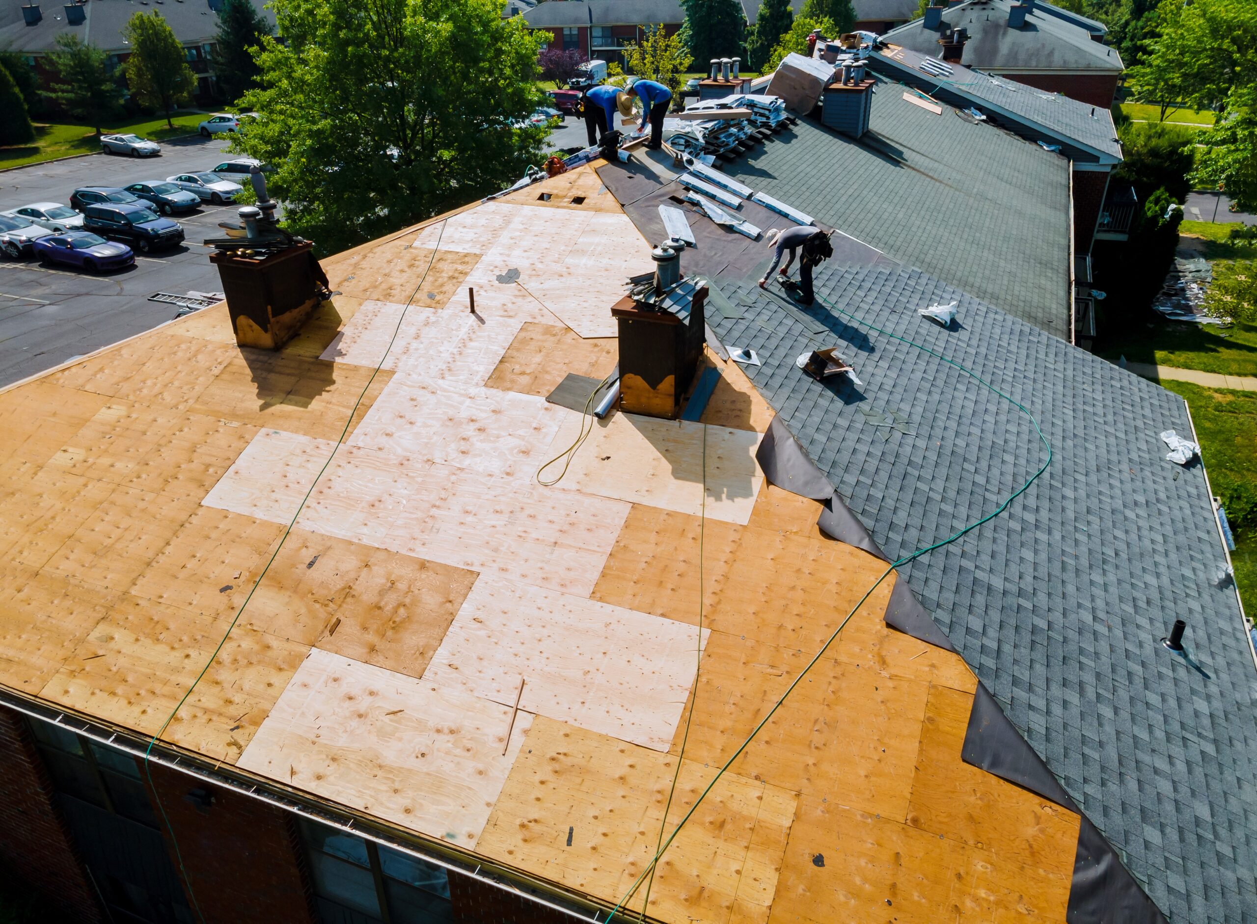 Old worn shingles being stripped and replaced with new ones during a roof repair